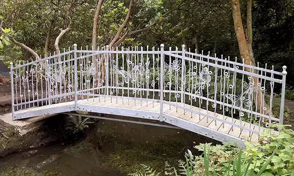 Wrought iron bridge over a pond with loop balustrades